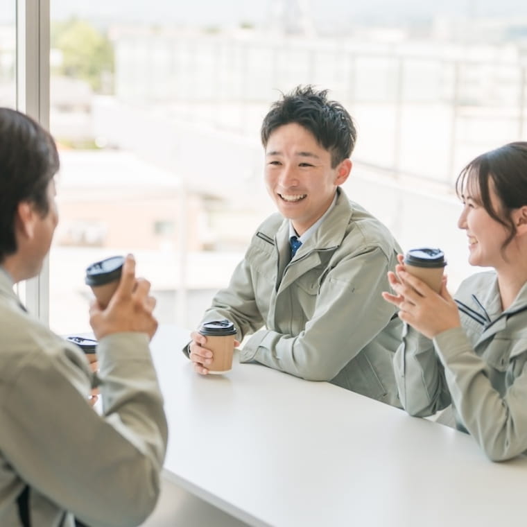 会話をする作業着の若手社員たち